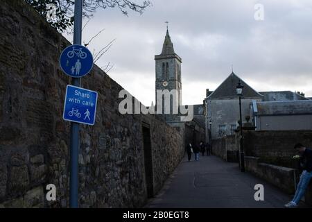 ST ANDREWS, SCHOTTLAND - 17/2/2020 - EIN Zeichen, das die Nutzung eines Pfades sowohl von Radfahrern als auch von Fußgängern mit Universitätsgebäuden im Hintergrund fördert Stockfoto