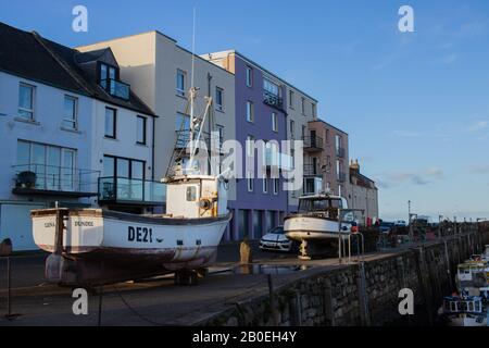 ST ANDREWS, SCHOTTLAND - 17/2/2020 - Boote vor bunten Häusern am Hafen von St. Andrews Stockfoto