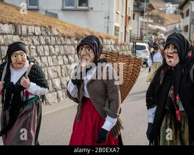 Die Menschen tragen Masken während des Karnevals in Dosoledo.Karneval in Dosoledo in Comelico ist eine Flamme von Farben, Blumen, Holzmasken und traditionellen Figuren. Stockfoto