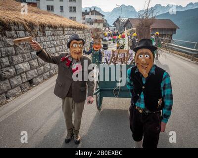 Die Menschen tragen Masken während des Karnevals in Dosoledo.Karneval in Dosoledo in Comelico ist eine Flamme von Farben, Blumen, Holzmasken und traditionellen Figuren. Stockfoto