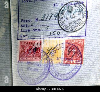 Alte britische blaue Pass-Seite mit Stempelmarken, eine von ihnen aus dem Jahr 1947, auf alten italienischen Lire Stempeln Stockfoto