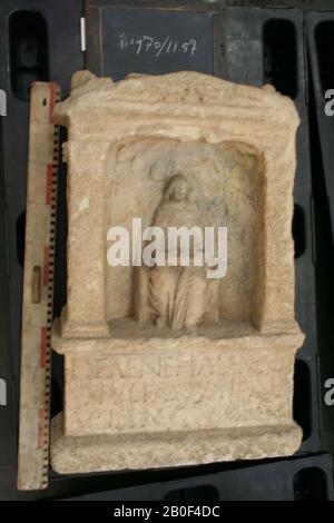 Flügelaltar mit Nische. Kalksteine. Nehalennia sitzt auf dem Sitz mit hohem, runder Rücken. Mit beiden Händen hält sie eine Schale Obst auf dem Schoß. Schalenförmiges Vordach. Kein Hund und kein Korb mit Früchten auf dem Boden neben ihr. Rechte Seite: Cornucopiae mit einem Globus unten. Auf der linken Seite ein Cornucopiae mit Schiffshelm. Die Rückseite ist undekoriert. Auf der Mensa in der Mitte links und rechts eine Birne, rechts beschädigt., Altar, Stein, Kalkstein, 87 x 57 x 25 cm, 181 kg, roman 150-250, Niederlande, Zeeland, Noord-Beveland, Colijnsplaat, Oosterschelde Stockfoto