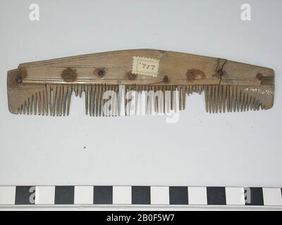 Einseitiger dreilagiges Kammaufsatz. Typ: Fragment eines langen Kamms. Dekoration: Horizontale Linien, die parallel zu den Kanten der Griffklinge verlaufen, und eine horizontale Doppellinienverzierung, die in der Mitte des Griffs platziert wird. Form: Längliche, gerade Basis, leicht gebogene Oberseite. Zahnplatten: 0. Endplatten: 0. Zähne: 0. Nieten: 3, zusätzlich 2 leere Löcher ohne Nieten, Teil eines Niets in einem Durchgangsloch und ein halbes Durchstechen ohne Nieten. Das Fragment besteht aus einer Griffelklinge, deren zwei Enden abgebrochen sind. Auf den Kammaufsatz aufgeklebte Beschriftungsplatte. Sägemarkierungen: Also zuerst die Griffklingen und Zahnplatten Stockfoto