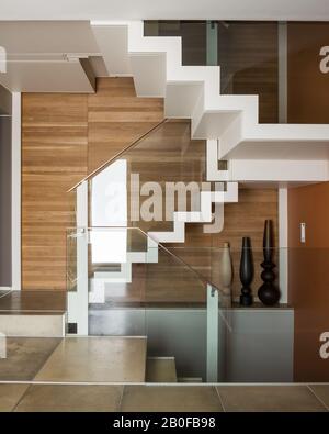 Holzgetäfelte Treppe mit modernem Glasbanner in der West London Wohnung Stockfoto