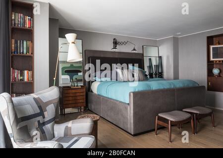 Diablo Modernist Bodenleuchte und gepolsterter Stuhl im Schlafzimmer der West London Wohnung Stockfoto