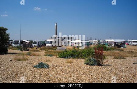 Ein Zimmer mit Blick, Wohnwagen und Reisemobile parkten am Strand am Fuße des alten Kamins des Kraftwerks Fawley, der abgerissen werden soll. Stockfoto