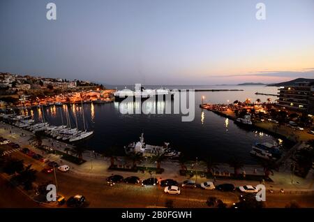 Kavala, Griechenland - 12. September 2014: Hafen in der Nacht mit Fährschiff und Segelschiffen, verschiedenen Häusern und Gebäuden in der Stadt in Eastmacedonia Stockfoto