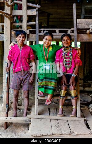 Herr Munney (Der Dorfjäger) Von Der ethnischen Gruppe Kayaw Posiert Mit Seiner Frau und EINEM Tourführer, Htay Kho Village, Loikaw, Myanmar, Außerhalb Seines Hauses. Stockfoto