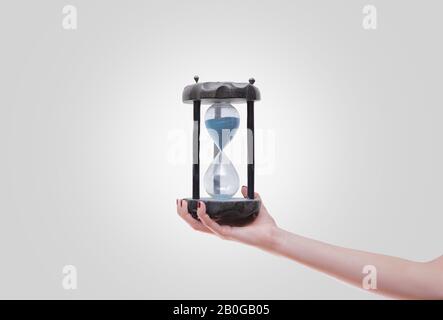 Frau mit Sanduhr in der Hand isoliert auf Weiß Stockfoto