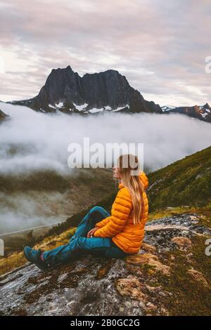 Frau mit Blick auf die Berge alleine reisen Abenteuerurlaub gesunder Lebensstil im Freien in Norwegen Ökotourismus Alleinreise Abendlandschaft Stockfoto