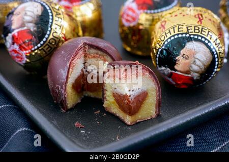 Tambov, Russische Föderation - 14. Februar 2020 Mozart Süßigkeiten auf schwarzem Teller. Eine Süßigkeit ist offen und geschnitten Stockfoto