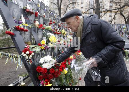 Kiew, Ukraine. Februar 2020. Ein Mann legt Blumen in Erinnerung an die himmlischen Hundert, Aktivisten, die bei Anti-Regierungs-Protesten 2014 in Kiew, Ukraine, am 20. Februar 2020 getötet wurden. Die Ukrainer feiern den 6. Jahrestag der Maidan-Revolution oder der Revolution Der Würde. Credit: Serg Glovny/ZUMA Wire/Alamy Live News Stockfoto