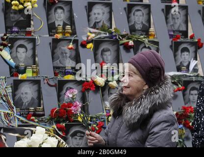 Kiew, Ukraine. Februar 2020. Eine Frau legt Blumen in Erinnerung an die himmlischen Hundert, Aktivisten, die während der Proteste gegen die Regierung 2014 in Kiew, Ukraine, am 20. Februar 2020 getötet wurden. Die Ukrainer feiern den 6. Jahrestag der Maidan-Revolution oder der Revolution Der Würde. Credit: Serg Glovny/ZUMA Wire/Alamy Live News Stockfoto