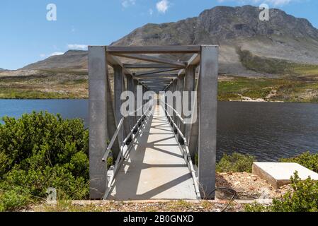 Buffels River, Westkaper, Südafrika. 2019. Buffels River Dam, Metallsteg über den Stausee und die Hottentots Holland-Berge Hintergrund. Stockfoto