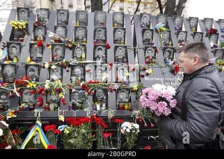 Kiew, Ukraine. Februar 2020. Ein Mann legt Blumen in Erinnerung an die himmlischen Hundert, Aktivisten, die bei Anti-Regierungs-Protesten 2014 in Kiew, Ukraine, am 20. Februar 2020 getötet wurden. Die Ukrainer feiern den 6. Jahrestag der Maidan-Revolution oder der Revolution Der Würde. Credit: Serg Glovny/ZUMA Wire/Alamy Live News Stockfoto