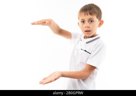 Der junge kaukasische Teenager zeigt etwas großes auf weißem Hintergrund Stockfoto