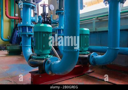 Vertikale Schlitzmotoren an Pumpen-Wasserleitung blau eingefärbt. Stockfoto