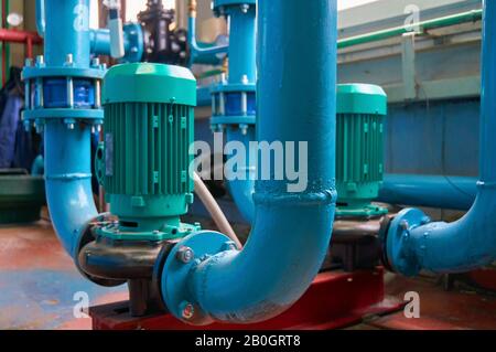 Vertikale Schlitzmotoren an Pumpen-Wasserleitung blau eingefärbt. Stockfoto