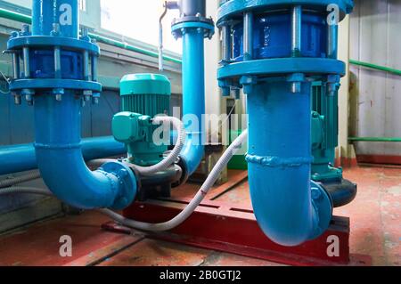 Vertikale Schlitzmotoren an Pumpen-Wasserleitung blau eingefärbt. Stockfoto