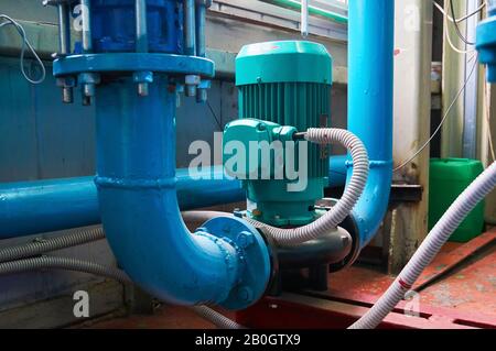 Vertikale Schlitzmotoren an Pumpen-Wasserleitung blau eingefärbt. Stockfoto