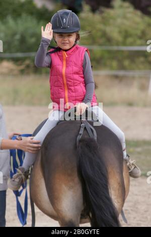 Junges Mädchen lernt, ein Pferd zu reiten Stockfoto