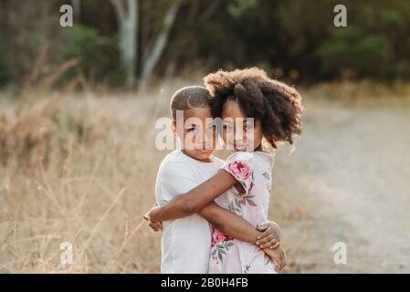 Nahaufnahme Porträt von drei sonnengeküssten Geschwistern lächelnd vor der Kamera Stockfoto