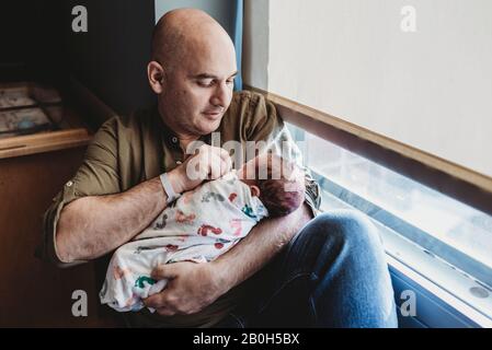 Vater hält neugeborenen Jungen in Decken im Krankenhaus verpackt Stockfoto