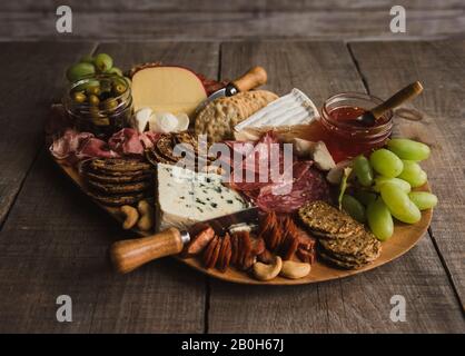 Schließen Sie die Wurstwaren aus Fleisch, Käse, Cracker auf Holztisch. Stockfoto