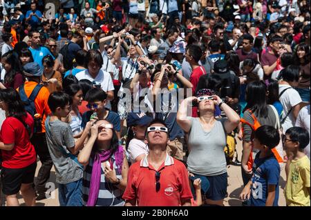 26.12.2019, Singapur, Singapur - Menschen versammeln sich im Amphitheater in Kebun Baru Springs, Ang Mo Kio, um die Sonnenfinsternis zu beobachten. 0SL19122 Stockfoto