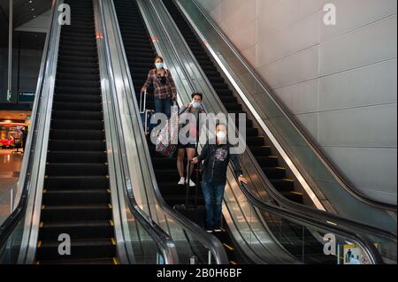 31.01.2020, Singapur, Singapur - Ankunft von Flugreisenden auf einer Rolltreppe zum U-Bahnhof am Flughafen Changi. Sie sind müde Stockfoto