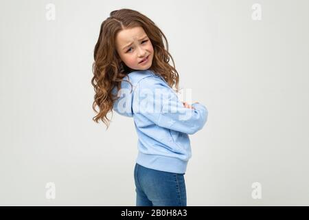 Beleidigtes Teenager-Mädchen in einer blauen Hoodie überquerte ihre Arme auf weißem Hintergrund Stockfoto