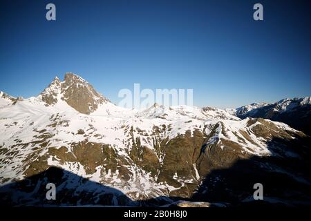 Schneebedeckte Berge in den Pyrenäen, die den Gipfel des Midi D'ossau hervorhebt. Ossau-Tal in den französischen Pyrenäen. Stockfoto