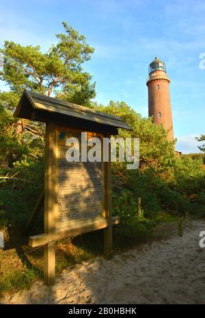 Darßer Ort, Deutschland 10-22-2019 Holz-Naturreservatsschild, und der historische Leuchtturm Stockfoto