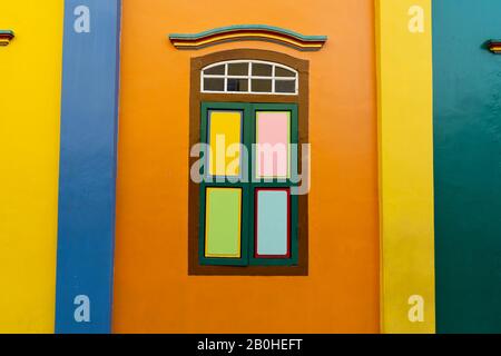 Fenster mit farbigem Glas in einer farbigen Fassade mit einem darüber liegenden Zierbogen. Reisekonzept Stockfoto