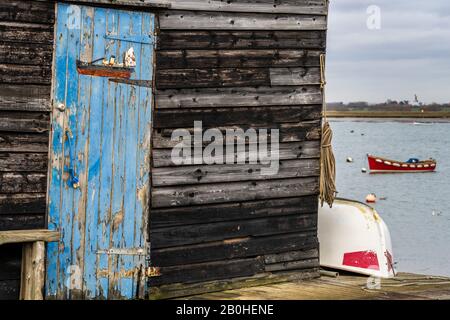 Alte Fischerhütten bei Felixstowe Ferry, einem kleinen Fischerdorf, 3 km nördlich von Felixstowe in Suffolk. Heringstreibplakette an der Tür. Stockfoto