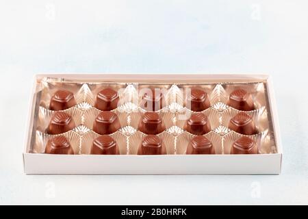 Sortiment an Luxus-Schokoladenbonbons in weißer Schachtel isoliert auf weißem Hintergrund. Schokoladen-Set mit exklusiven handgefertigten Süßigkeiten. Kopierbereich Stockfoto