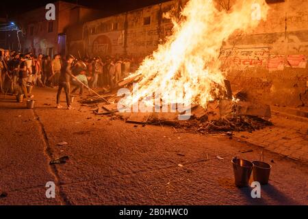 Die Menschen, die Kohle ausziehen, bezeichnen die sagenhafte Figur des Prahlad aus dem traditionellen Holika-Dahan-Feuer auf das Hindufest von Holi. Vrindavan. Indien Stockfoto