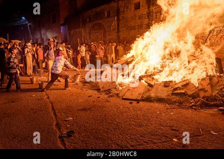 Die Menschen, die Kohle ausziehen, bezeichnen die sagenhafte Figur des Prahlad aus dem traditionellen Holika-Dahan-Feuer auf das Hindufest von Holi. Vrindavan. Indien Stockfoto