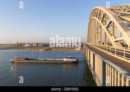 Nijmegen, Niederlande - 16 November 2018: cargo Binnenschiffe vorbei unter Waal Brücke in Nimwegen während der Zeit des niedrig Stockfoto