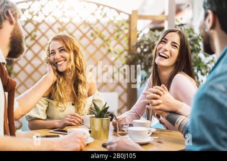 Fröhliche Freunde, die Cappuccino in der Cafeteria trinken - Ein Junges romantisches Paar, das Spaß hat, gemeinsam Zeit zu verbringen Stockfoto