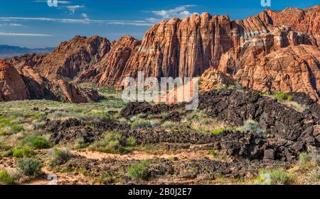 Wanderer am Lavastrom Trail, Basalt vulkanischen Felsen und Navajo Sandstein Felsformationen, bei Snow Canyon State Park, Utah, USA Stockfoto