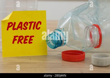 Plastikflaschen und eine gelbe Karte mit den Worten "Plastic Free" Das Konzept, den Einsatz von Kunststoff zur Pflege der Umwelt zu reduzieren Stockfoto