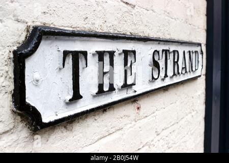 The Strand. Klassisches britisches Straßenschild an weißer Ziegelwand in Derby, England. Stockfoto