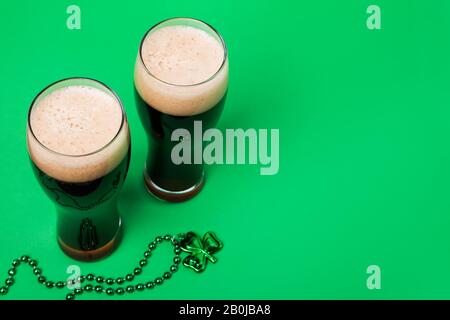 Zwei Gläser dunkles Bier und traditionelles Kleeblattdekor Stockfoto