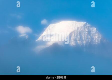 Mt. Robson Summit vom Ufer des Berg Lake aus gesehen durch Nebel im Mount Robson Provincial Park, British Columbia, Kanada Stockfoto