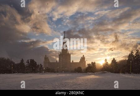 Schneefall gegen die untergehende Sonne und die Moskauer Staatsuniversität Stockfoto