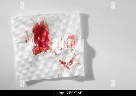 Küchenpapier Serviette im Blut. Blut mit improvisierten Mitteln stoppen. Stockfoto