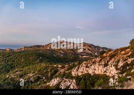 Sonnenaufgang am Calanque de Morgiou (Marseille, Frankreich): Die atemberaubende Berglandschaft auf den Klippen unter warmem, weichem Sonnenlicht Stockfoto