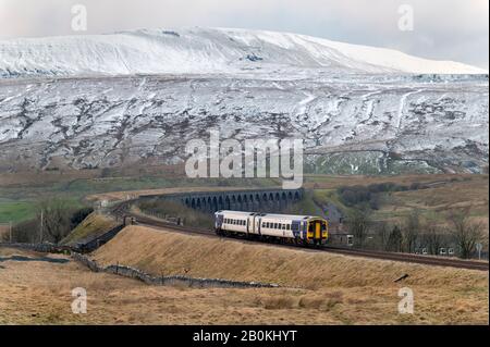 Ein Personenzug der Northern Rail Sprinter überquert den berühmten Ribblehead Viaduct im Yorkshire Dales National Park, Großbritannien. Whernside Peak liegt zurück. Stockfoto