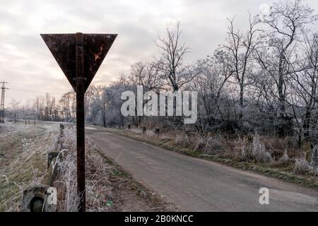 Ertragsanzeichen auf einer Winterstraße in der ungarischen Landschaft. Stockfoto